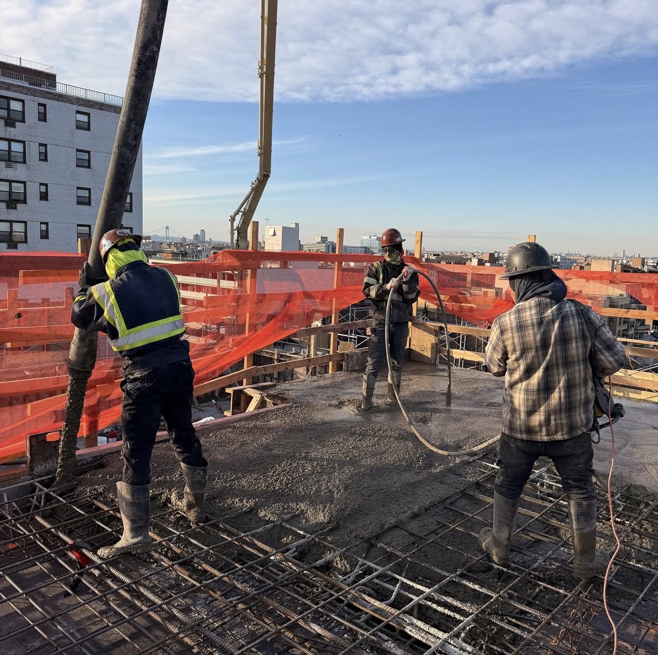 AGC workers pouring concrete into a rebar-reinforced elevated structural slab